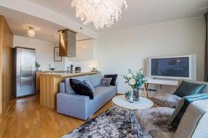 a living room with a blue couch and a kitchen at City Center Luxury Apartment in Tartu