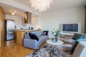 Una sala de estar con un sofá azul y una cocina. en City Center Luxury Apartment, en Tartu