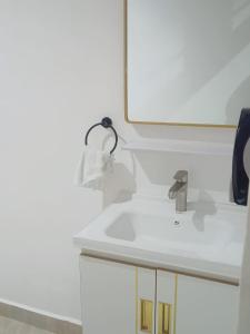 W łazience znajduje się biała umywalka i lustro. w obiekcie Lagos Diani w mieście Diani Beach