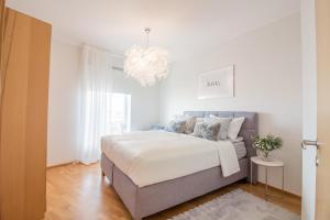 a bedroom with a bed and a chandelier at City Center Luxury Apartment in Tartu