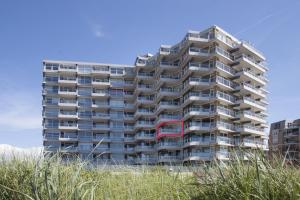 een groot appartementencomplex met een rood raam bij Studio Noordzee in Egmond aan Zee