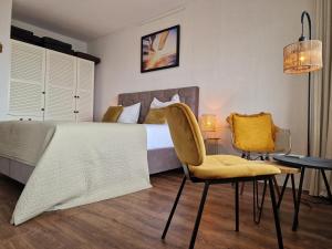 1 dormitorio con 1 cama, mesa y sillas en Studio Noordzee en Egmond aan Zee