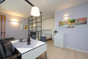 uma cozinha e sala de estar com mesa e cadeiras em Casa Lugana 9 - monolocale con piscina fronte lago em Sirmione