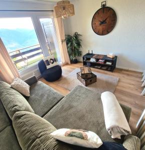 a living room with a couch and a large window at Vue imprenable sur les Alpes et Parking privé gratuit in Crans-Montana
