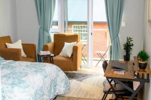 a bedroom with two chairs and a bed and a table at Entire Studio Apartment in Maboneng in Johannesburg