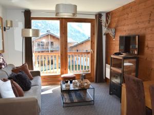 a living room with a couch and a large window at Bel appartement avec piscine, sauna et parkings à Pralognan-la-Vanoise - FR-1-464-217 in Pralognan-la-Vanoise