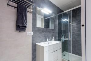 a bathroom with a white sink and a shower at Apartamentos Basílica Santa Eulalia PARKING INCLUIDO in Merida