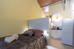 um quarto com uma cama e uma cozinha com um frigorífico em Apartamentos Basílica Santa Eulalia PARKING INCLUIDO em Mérida
