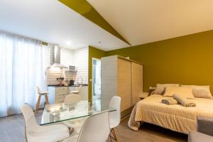 um quarto com uma cama, uma mesa e cadeiras em Apartamentos Basílica Santa Eulalia PARKING INCLUIDO em Mérida