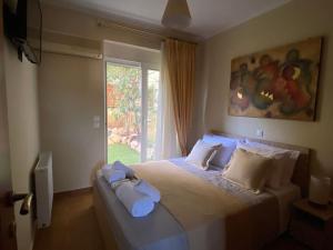 a bedroom with a large bed with towels on it at Pool Garden House near the Sea in Vari +24 photos