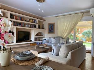 a living room with a couch and a tv at Pool Garden House near the Sea in Vari