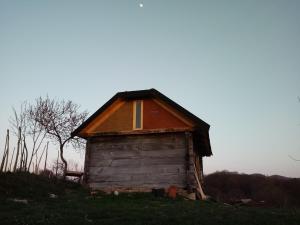 une petite maison en bois installée au sommet d'une colline dans l'établissement Deda Vinko Off Grid Cabin, à Ključ