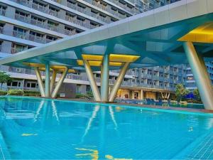 a large swimming pool in front of a large building at 1BR w/ Balcony near Megamall: The Admiral‘s Lounge in Manila