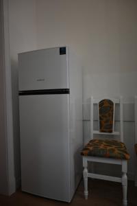 a white refrigerator in a room with a chair at Hotel Korona in Verbovatovka