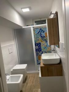 a bathroom with a sink and a toilet and a shower at Casa Sofia - Appartamento ristrutturato a Castiglione della Pescaia, località Rocchette in Castiglione della Pescaia