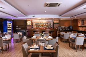 restauracja ze stołami i krzesłami oraz bar w obiekcie Anemon Cigli Hotel w mieście Izmir
