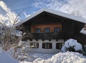 una casa cubierta de nieve con nieve en NEU - traumhafte Ferienwohnung mit Bergblick en Lenggries
