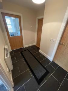 a hallway with a door and a black tile floor at Central 2 bedroom apartment in Wick