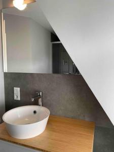La salle de bains est pourvue d'un lavabo blanc sur un comptoir en bois. dans l'établissement Kleine gemütliche Haushälfte, à Keitum