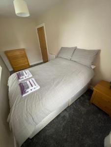 a bedroom with a large bed with a night stand at Central 2 bedroom apartment in Wick