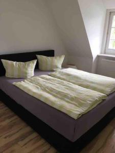 - un lit avec 2 oreillers dans une chambre dans l'établissement Kleine gemütliche Haushälfte, à Keitum