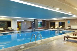 ein Pool in einem Hotel mit Stühlen und Tischen in der Unterkunft Anemon Kent Çiğli Otel in Izmir