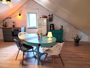 uma cozinha com mesa e cadeiras num quarto em bloom-inn gastvrij genieten em Doornenburg