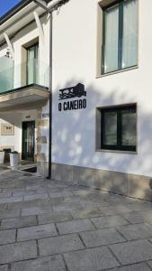a building with a sign on the side of it at Apartamentos O Caneiro in Portomarin