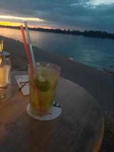 a drink sitting on a table next to the water at River Hostel Belgrade in Belgrade