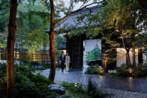 un hombre y una mujer entrando en un edificio en HOTEL THE MITSUI KYOTO, a Luxury Collection Hotel & Spa, en Kioto