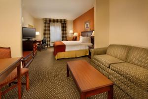 une chambre d'hôtel avec un lit et un canapé dans l'établissement Holiday Inn Express & Suites by IHG Chambersburg, an IHG Hotel, à Chambersburg
