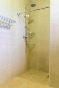 La salle de bains est pourvue d'une douche avec une porte en verre. dans l'établissement Sir Edwards two bedroom Inn at Masaki, à Dar es Salaam