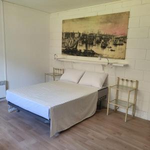een slaapkamer met een bed en een schilderij aan de muur bij Le Jardin De Nicolas in Couret
