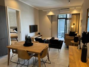 a living room with a dining table and a living room at Menlyn Maine Triology - 10 On Capital in Pretoria