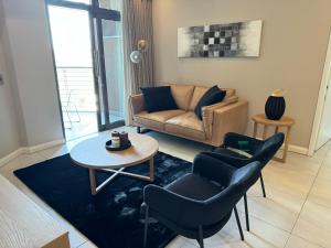 sala de estar con sofá, 2 sillas y mesa en Menlyn Maine Triology - 10 On Capital, en Pretoria