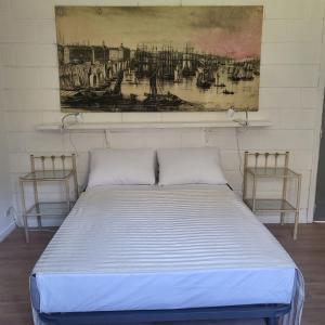 een bed in een kamer met 2 stoelen en een schilderij bij Le Jardin De Nicolas in Couret