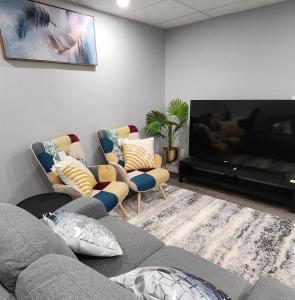 een woonkamer met een bank en een flatscreen-tv bij Entire Basement Suite with Private Entrance in Winnipeg