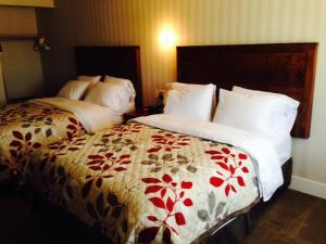 Habitación de hotel con 2 camas con sábanas blancas y rojas en Motel Beausejour en Neguac