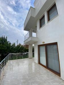 a large white house with a balcony on a patio at Kiralık Yazlık in Kuşadası