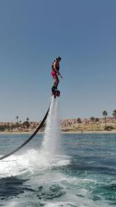 a person on a water board in the water at AYAHAY, Modern luxury apartment just 50 m from Playa Del Puerto in Puerto de Mazarrón