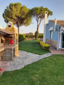 a backyard with a stone dog house and trees at Casa Golf Azul - Suite Viagens in Aljaraque