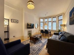 a living room with a couch and a table at Rowan’s Place in Holborn in London