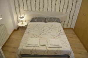 a bed in a bedroom with a tree patterned wall at Los Castaños de Burgos in Burgos