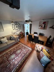 a living room with a couch and a dining room at The Hanging Gate Coach House in Madeley