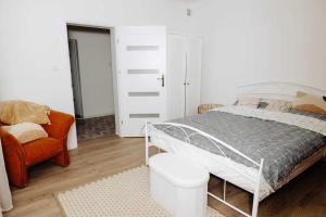 um quarto com uma cama, uma cadeira e um closet em Las i Rzeka em Wyszków