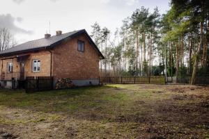 uma casa de tijolos num quintal com uma cerca em Las i Rzeka em Wyszków