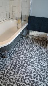 a bathroom with a tub and a tile floor at Cute Fisherman's Cottage in the Heart of Brighton in Brighton & Hove