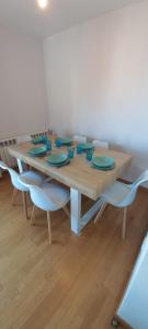 una mesa de madera con sillas y platos azules. en Apartamento con 2 dormitorios, garaje y terraza junto a Valladolid en Valladolid