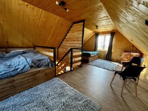ein Schlafzimmer in einem Blockhaus mit einem Bett und einem Schreibtisch in der Unterkunft Laski Lake Domek na Mazurach in Kallinowen