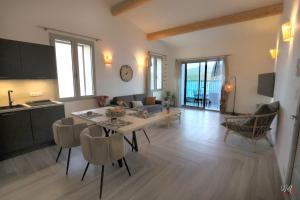 a kitchen and a living room with a table and chairs at Résidence Cas’Antica in Propriano